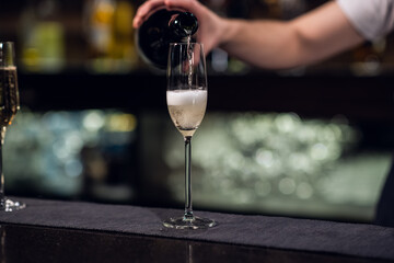 close-up of a glass of champagne poured from a bottle.