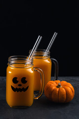 Pumpkin mocktail in jars with halloween face