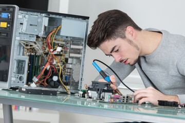 young computer technician using soldering iron