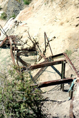 An old ruined metal staircase in the cliff leading to the sea beach
