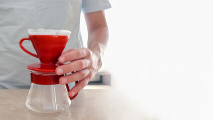Set for making V60 on the table. Men's hand holds glass server. Pourover