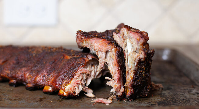Tender Baby Back Ribs with a nice bark, sliced before being served,  looking mouth watering delicious