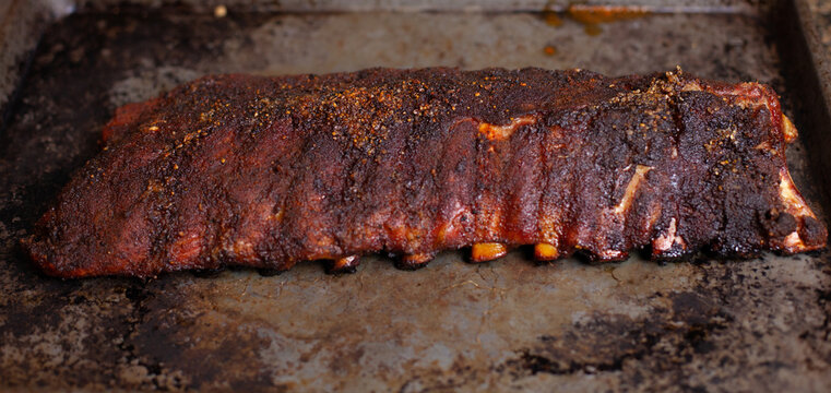 Baby Back Ribs with a nice bark, resting before being served, cooked and looking mouth watering delicious
