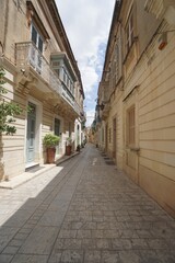 Narrow old road featuring old houses and stone wall and floors