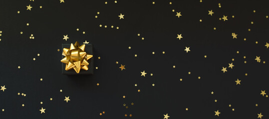 Black boxes of gifts on a black background with gold stars. Black Friday super sale. Horizontal banner, poster, website header