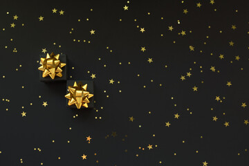 Black boxes of gifts on a black background with gold stars. Black Friday super sale.Flat lay