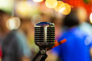 Stylish metal vocal microphone with blurry lights background