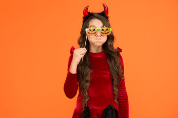 halloween child in suit and imp hors with pumpkin party glasses makes faces emotionally, halloween...