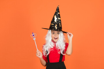 happy halloween witch girl. teenage child in witch hat. cheerful kid use magic wand. work wonders. carnival costume party. trick or treat. celebrate the holidays. childhood happiness