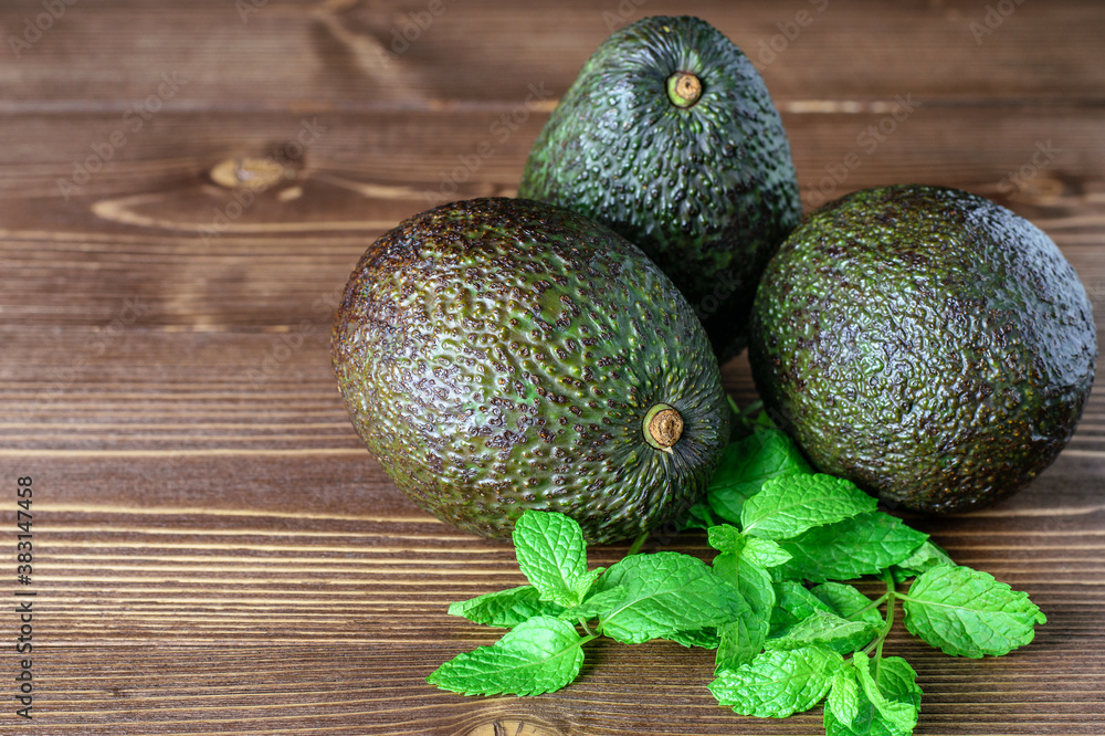 Wall mural Fresh organic big avocados on the wooden background close-up.