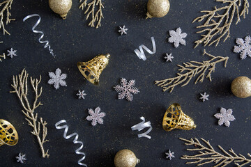 Flat lay New Year Christmas black background pattern decorated with Happy Christmas garlands, snowflakes, golden bells