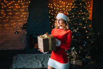 Obraz na płótnie Canvas beautiful woman near a Christmas tree with gift