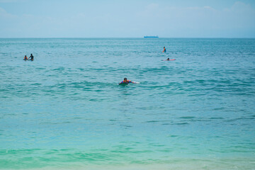 Sexy slim girl riding on surf board in the ocean. Healthy active lifestyle in summer vocation.