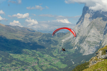 Closeup of a red para glider flying in Swiss Alps. 
