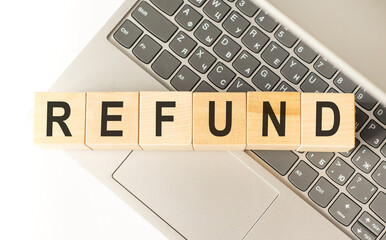 Word refund. Wooden cubes with letters isolated on a laptop keyboard. Business Concept image.