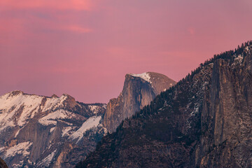 Snowy Half Dome bathed in a winter sunset.