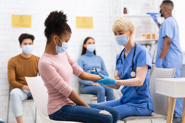 African American Teen Girl Receiving Coronavirus Vaccine Injection In Hospital