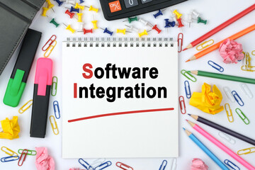 On the table is a calculator, diary, markers, pencils and a notebook with the inscription - Software Integration