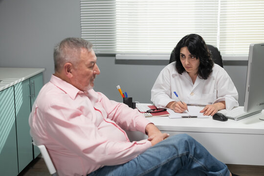 A doctor talking to her depressed male patient at her office.