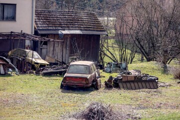 Scrapyard on a garden behind a house full of old abandoned cars from Eastern Europe.
