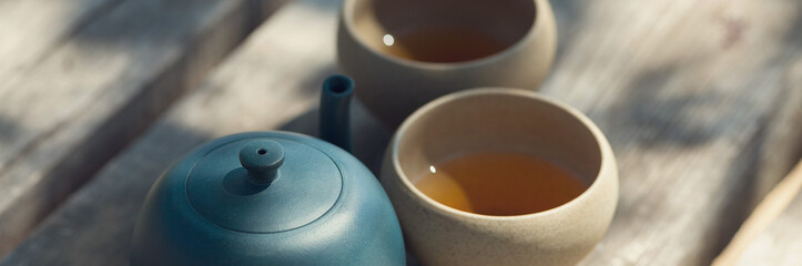 Chinese tea ceremony. Ceramic teapot made of clay and bowls on a wooden background. - obrazy, fototapety, plakaty