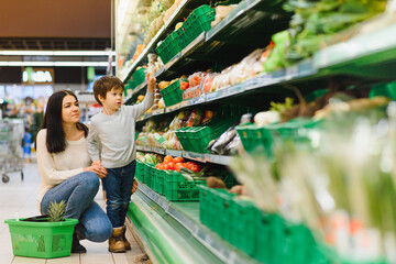 Obraz premium mother and her son buying fruits at a farmers market