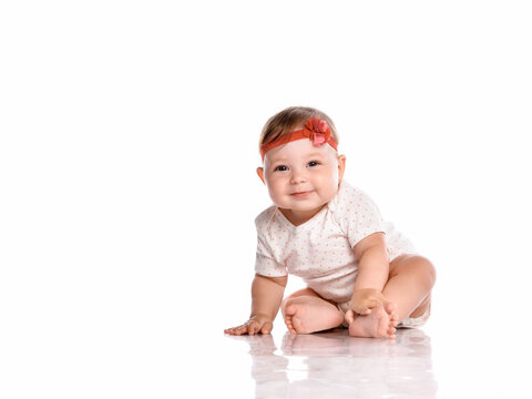little baby girl laughing, creeping playing in the studio, isolated on white background