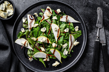 Blue cheese salad with , pears, nuts, chard and arugula. Black background. Top view