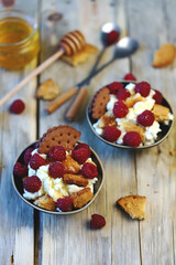 Mascarpone dessert with raspberries and biscuits in bowls.