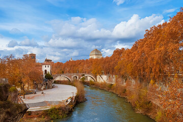 Autumn and foliage along River Tiber. Beautiful red, orange and yellow leaves near Tiber Island in Rome historic center