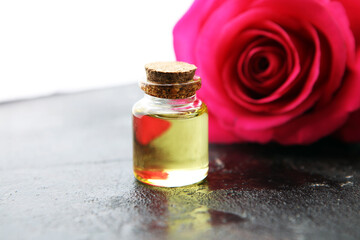 pink rose flower and glass of bottle essential oil. spa and aromatherapy cosmetic concept.