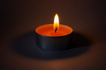 Obraz na płótnie Canvas Candle on dark luxury night background. Black table, side view. Candles Burning at Night. Orange taper burning in focus, foreground. illustration design.