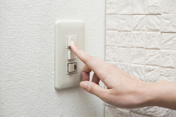 電気をつける女性