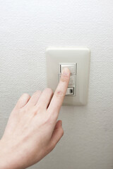 電気をつける女性