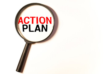Hand holding magnifying glass with words action plan concept.
