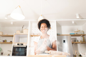 Woman having fun with flour in kitchen