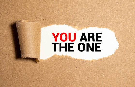 A man is holding a piece of paper which is saying 'You are the one '