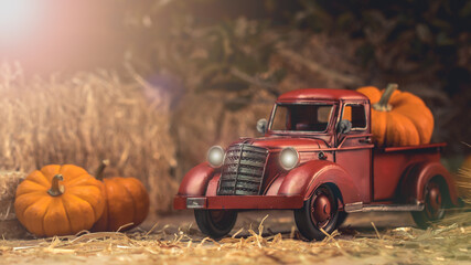 Autumn composition. Red pickup truck with pumpkin and straw bale. Farm country style decorations....