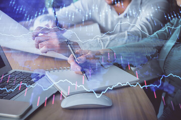 Double exposure of forex chart drawing over people taking notes background. Concept of financial analysis