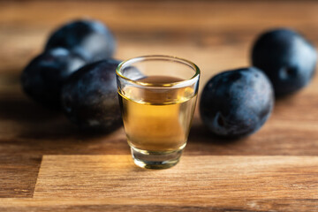 Close up on homemade strong alcohol drink from plum brandy in shot glass rakia brandy called slivovitza traditional drink made in serbia croatia bulgaria or bosnia with selective focus dark background