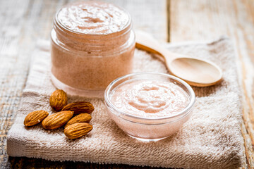 spa concept with almond nuts and scrub on wooden background
