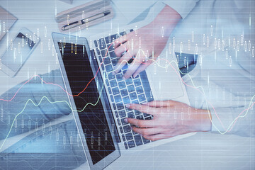 Double exposure of woman hands working on computer and forex graph hologram drawing. Top View. Financial analysis concept.
