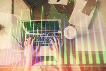 Double exposure of woman hands working on computer and forex chart hologram drawing. Top View. Financial analysis concept.