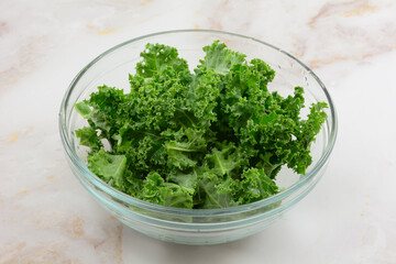 Freshly rinsed and destalked raw fresh kale in ingredient bowl