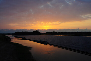 Sunset rays over solar panels on the lake.