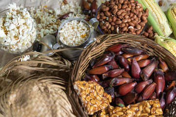 Wicker basket with typical Brazilian foods like pine nuts, popcorn, brown sugar, peanuts and green corn
