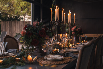 Christmas table with candles, flowers and glass cups.