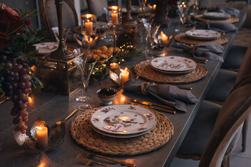 Christmas table with candles, flowers and glass cups.