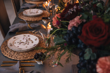 Christmas table with candles, flowers and fruits