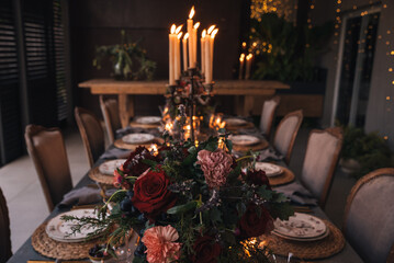 Christmas table with candles, flowers and fruits